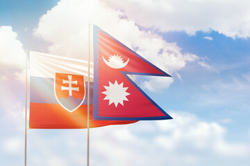 Sunny blue sky and flags of nepal and slovakia
