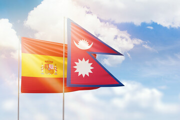 Sunny blue sky and flags of nepal and spain