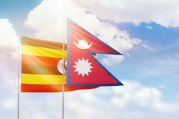 Sunny blue sky and flags of nepal and uganda