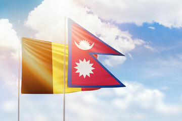 Sunny blue sky and flags of nepal and belgium