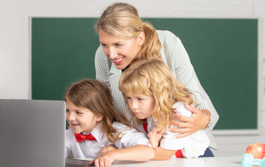 School pupil with teacher learning at laptop computer, studying with online education e-learning in...