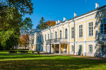 Fototapeta na wymiar Sunny autumn weather drew tourists and visitors to enjoy the beautiful Vääna Manor, Estonia. Built in the 18th centur. Main building now houses a school.