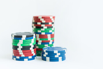 Stacks of poker chips including red, black, white, green and blue on a white background