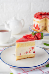 Fraisier mousse cake. Strawberry cake with biscuit, mousse and jelly on a white wooden background. Summer dessert. Selective focus. Copy space.