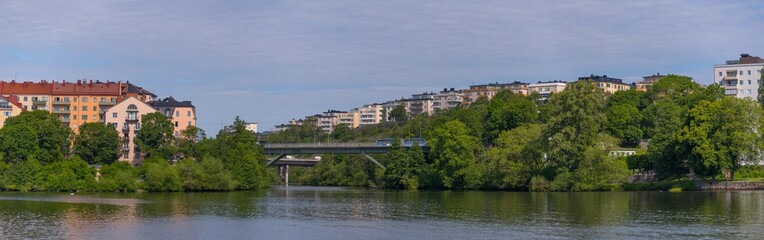 The high way bridge between the island Lilla Essingen and Kungsholmen with water front color full apartment houses a sunny summer day in Stockholm