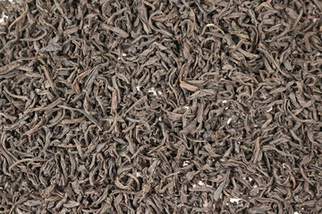 Black tea leaves spread on surface background
