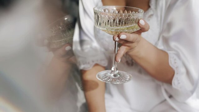 The girl is holding a large glass of wine in her hands. Close-up shooting of hands