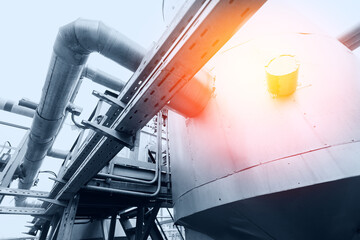 Industrial background concept. Steel pipelines, valves gas and oil refinery plant form industry zone with sunlight, blue toning
