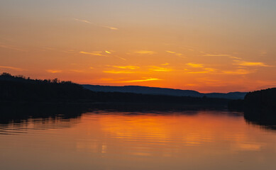 Fototapeta na wymiar Spectacular sunset on the Danube. Forest, river and a beautiful sunset.