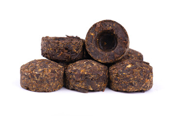 Puer tea isolated on white background. Close up. Fermented and compressed tea leaves. Round flat disc of puer tea.