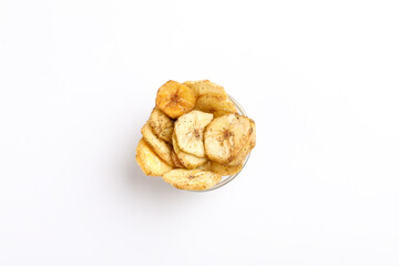 Salty banana chips in bowl on white background.