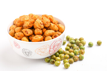 Fried coated peanuts and green peas on white background. Delicious snack.