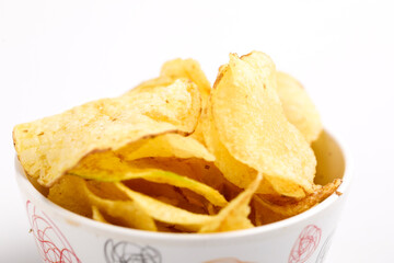 potato chips in bowl on white background.