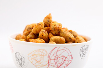 Roasted coated peanuts on white background. Delicious snack peanut.