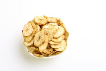Salty banana chips in bowl on white background.