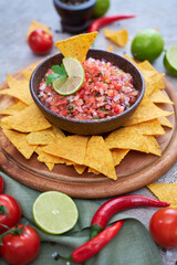 freshly made salsa dip sauce with nacho chips on wooden board - obrazy, fototapety, plakaty