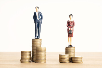 Wage difference between men and women concept. Man and woman standing on top of the pile of coins