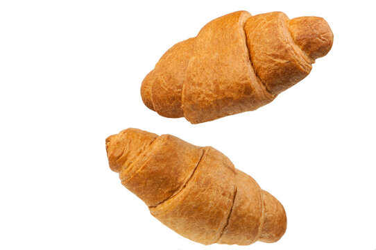 Croissants brioche bun flies in the air. Freshly baked puff pastry cookies fall on white. Delicious French baked croissants with almonds. Levitation, bakery cafe concept
