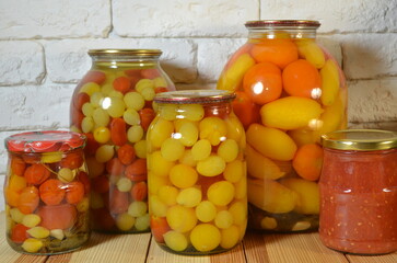 Pickled tomatoes. Stelanny jars with cherry tomatoes. Tomato juice. Cherry red, yellow, white.