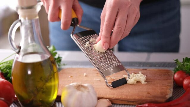 making salad sauce - grating garlic at a domestic kitchen