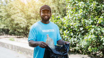 Experienced senior volunteer holding garbage bag and staring at camera