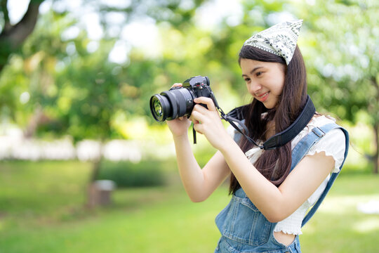 Pretty attractive girl standing in the public garden looking at camera to see the picture with copy space on sunny day. Happiness during vacation. Relaxation, Aromatherapy freedom feeling lifestyle