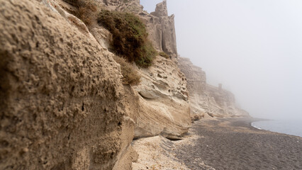 Lunar landscape: Eroded pumice forms bizarre cliffs at so-called Moon Beach at Vlychada, looking eerie with incoming mist