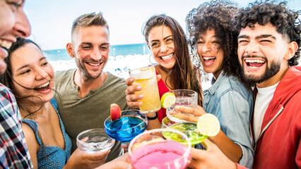 Multiracial young people cheering cocktail glasses outside on rooftop party - Happy friends having fun enjoying happy hour at bar restaurant - Youth lifestyle concept
