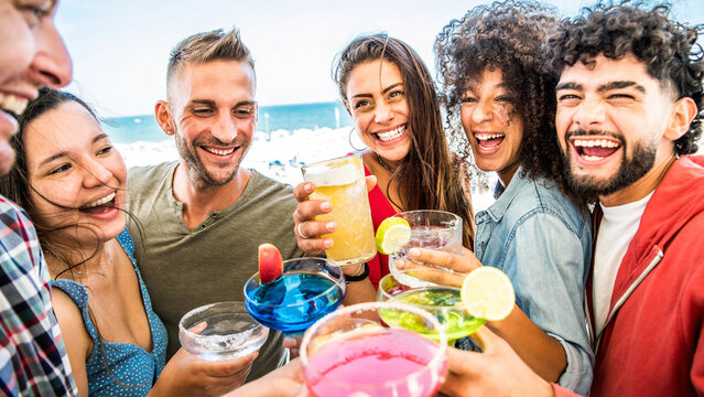 Multiracial young people cheering cocktail glasses outside on rooftop party - Happy friends having fun enjoying happy hour at bar restaurant - Youth lifestyle concept - Powered by Adobe