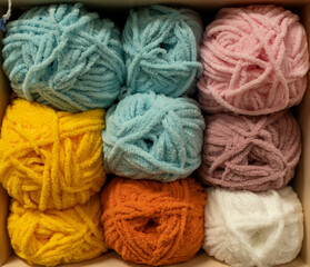 Close Up of yarn balls. Rainbow colors. Yarn for knitting. Skeins of yarn. Knitting needles, colorful threads. Knitting background, Knitting yarn for handmade winter clothes.