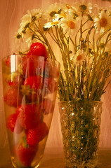 vases filled with strawberries and daisies