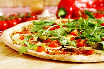 Freshly baked pizza with arugula, tomato, olive, mushrooms, sweet pepper, hollandaise sauce and mozzarella