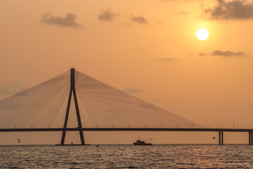 sunset near mumbai worli bandra sea link bridge and small boat in ocean