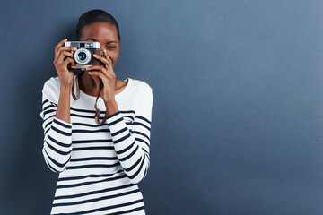 Smile. Shot of an attractive young woman taking a photo with a vintage camera.