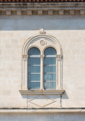 Fragment of the facade of a Mediterranean building with a beautiful window and relief decor