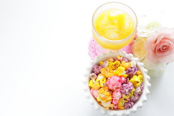 Multiple color popcorn and glass of orange juice 