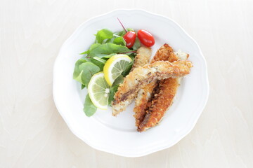 Homemade bread crumbs sardines fillet fried served with baby leaves and cherry tomato