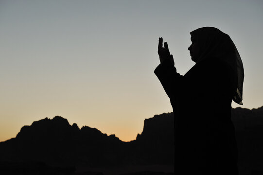 silhouette of a muslim woman praying on the