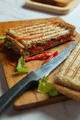 Crispy ham sandwich on wooden cutting board 
