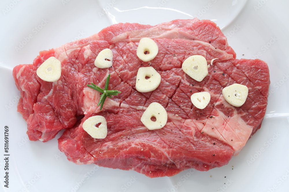 Sticker seasoning beef steak, garlic and pepper on plate