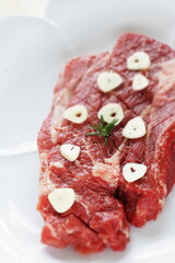 Seasoning beef steak, garlic and pepper on plate