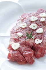 Seasoning beef steak, garlic and pepper on plate
