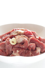 Seasoning cut beef steak, garlic and pepper on plate