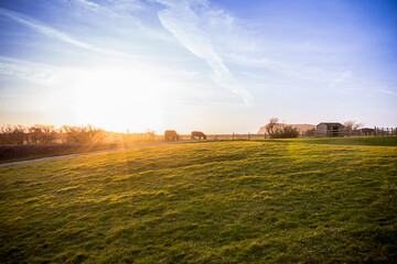 Fototapeta premium Beautiful sunset over a farm in Uphill, Weston- Super-Mare. Sunset is also known as sundown, is the daily disappearance of the Sun below the horizon due to Earth's rotation.