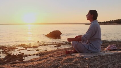 Woman meditating, zen yoga meditation practice breath exercise in nature. Yogi girl is sitting in sunset, healthy lifestyle, meditation concept