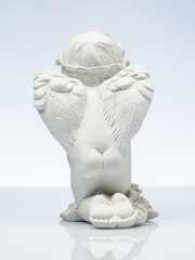 plaster white statuette in the form of an angel on a white background