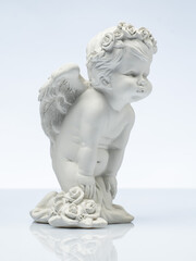 plaster white statuette in the form of an angel on a white background