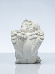 Obraz premium plaster white statuette in the form of an angel on a white background