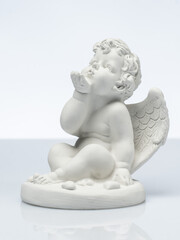 plaster white statuette in the form of an angel on a white background