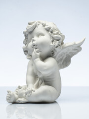 plaster white statuette in the form of an angel on a white background